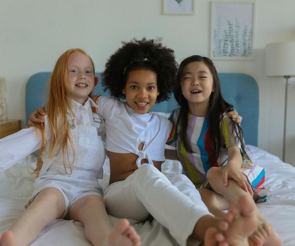 Group of diverse kids laughing and stretching in a bright room.